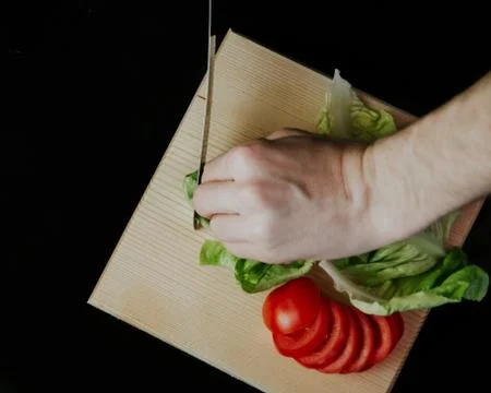 Slicing vegetables on chopping board Stock Photos