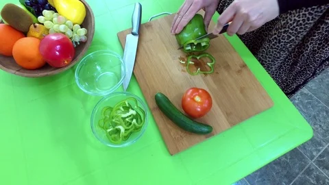 Slicing vegetables on a green table. Stock Footage 76686395