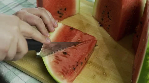 Slicing watermelon into triangles on chopping board - closeup, slow motion shot Stock Footage 341246710