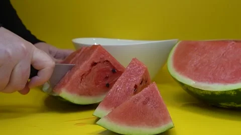 Slicing watermelon on a yellow background. Stock Footage 320569942