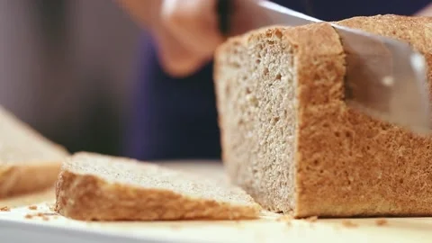 Slicing whole wheat bread on cutting board. Stock Footage 152518611