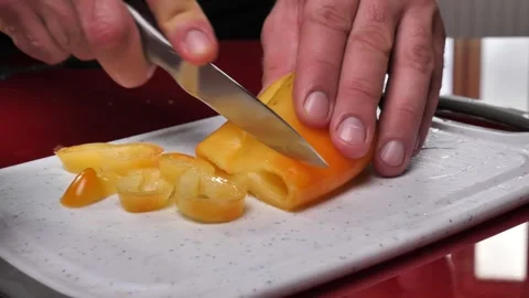 Slicing a yellow pepper with a knife on a kitchen board Video stock 255287609