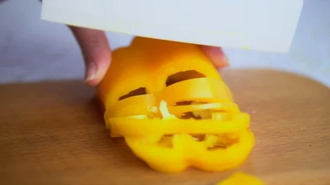 Slicing yellow pepper with a white ceramic knife Stock Footage 75567730