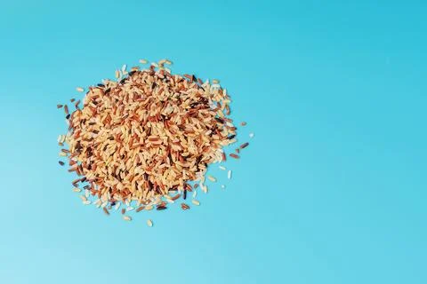 Slide of different types of rice on blue background Stock Photos