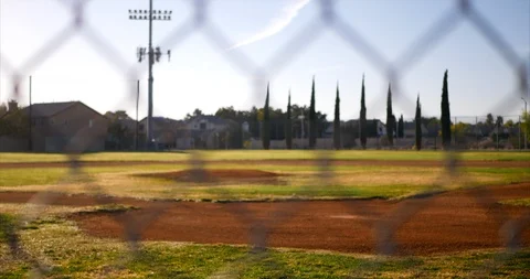 Slide down shot looking out at an empty green baseball field diamond from Stock Footage 97495744