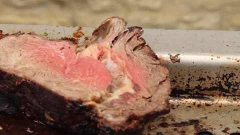 Slide forward over 2 cuts of beef at a BBQ Stock Footage 80437048