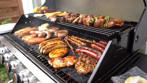 Slide left close up shot of hand using tongs for turning meat on the barbecue in Stock Footage 136735635