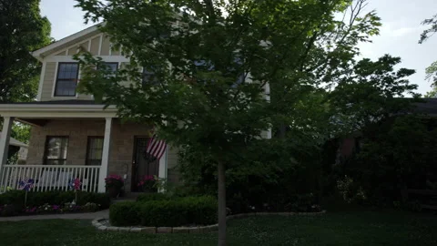 Slide to the left in front of a nice house with patriotic decorations. Stock-Footage 197424548