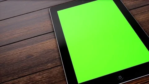 A Slide left of tablet displaying green screen at angle on desk Stock Footage 155224039