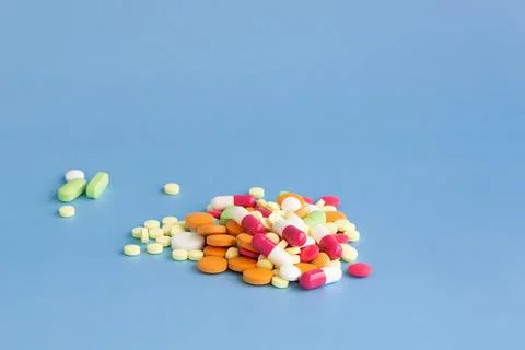 A slide of multi-colored pills on a blue background. Stock Photos