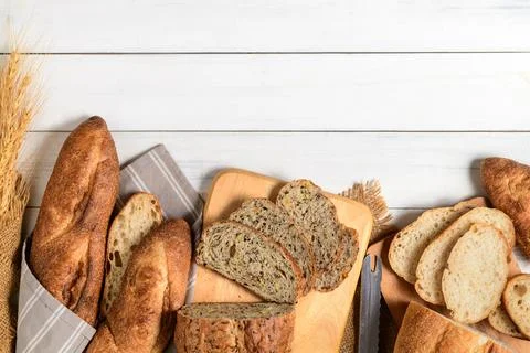 Slide multi grain sourdough bread and sliced Baguette on white wood 스톡 사진