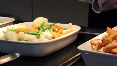 Slide from right to left across a hot buffet as steam veg is served Stock Footage 80435227