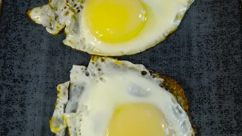 Slide shot of fried eggs on a plate. Slow Macro Dolly for an appetizing lunch Stock Footage 221854874