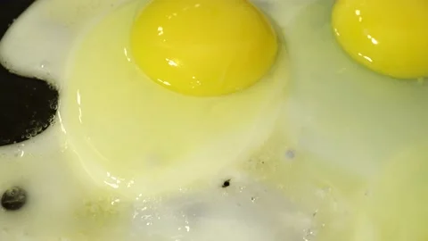 Slide shot of the process of making fried eggs. Macro dolly cooking scrambled Stock Footage 202888633