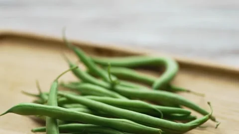Slide shot of raw organic string beans placed on a wooden table Stock Footage 343555467