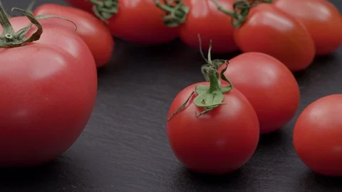 Slide shot of red tomatoes on black stone UNGRADED Stock Footage 120571996