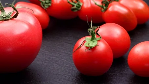 Slide shot of red tomatoes on black stone Stock Footage 120572884