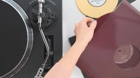 Slide the side view to the hands of the DJ girl pulls out a red vinyl plate Video stock 91721827