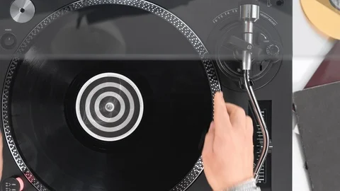 Slide the side view to the hands of the DJ's girl put a black vinyl record Stock Footage 91721200