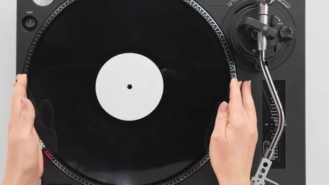 Slide the side view to the hands of the DJ's girl put a black vinyl plate Stock Footage 91721219