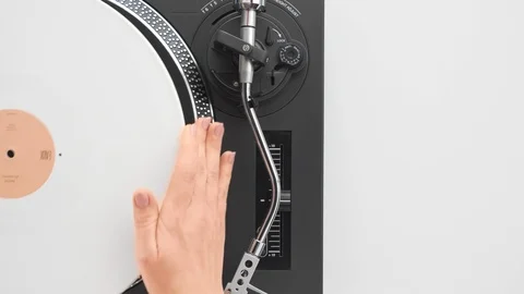 Slide the side view to the hands of the DJ's girl put a white vinyl plate Stock Footage 91721489