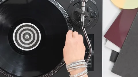 Slide the side view to the hands of the DJ's girl put a black vinyl record Stock Footage 91721916