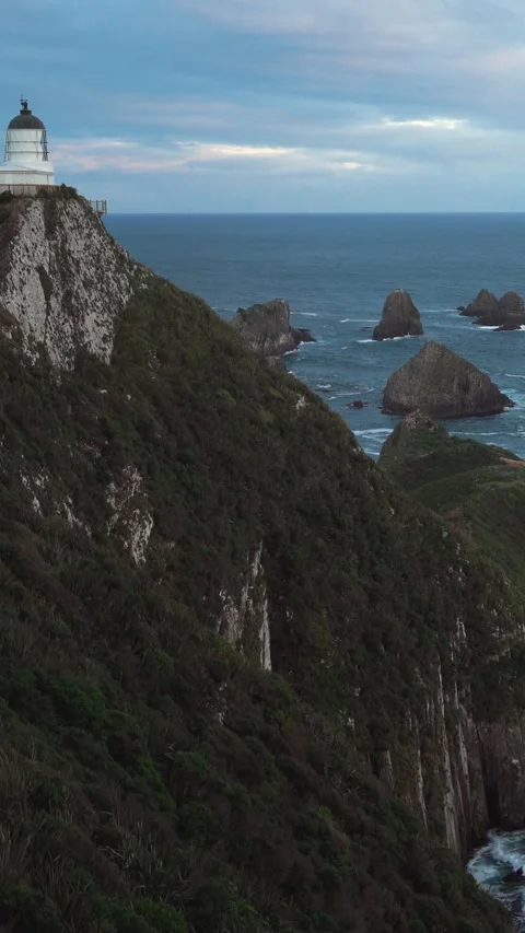 Slide transition of amazing peninsula with lighthouse at cloudy dusk Stock Footage 288496748