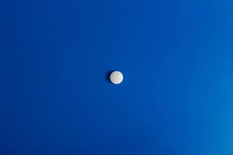 Slide of white tablets on a light table. Stock Photos