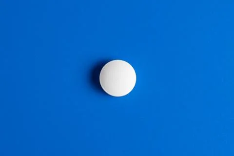 Slide of white tablets on a light table. Stock Photos
