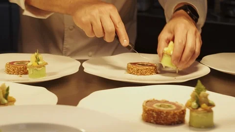Slider of a chef finishing the presentation of a dish on plates Stockbeeldmateriaal 92080883
