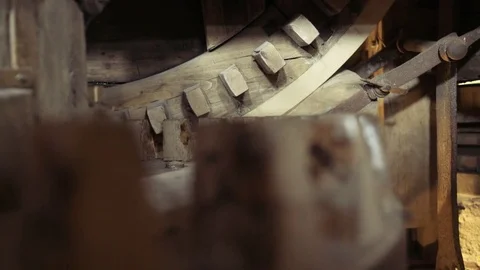 Slider left to right close up of a big old crafted wooden gear inside a windmill Stock Footage 85215315
