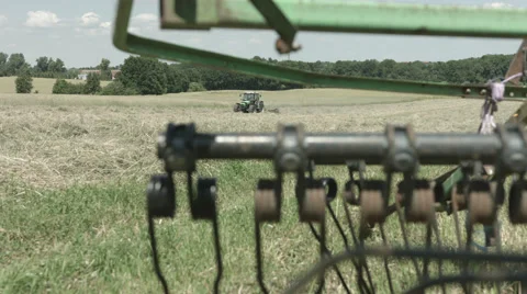 A slider move on a Field while a Tractor is driving in the Background in 4K Stock Footage 66450016