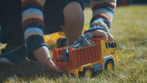 Slider shot of 3 year old boy playing with truck outside. Child playing with Stock Footage 104773779