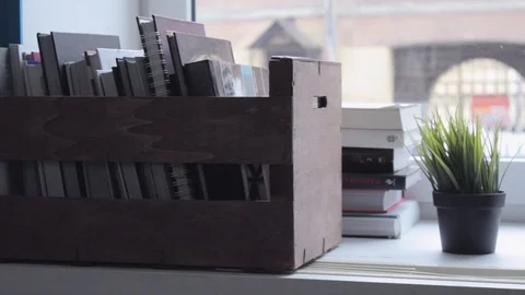 Slider shot of box with books on window, rollover shot Stock Footage 101308934