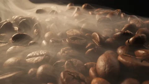 Slider shot of coffee beans during roasting. Roasting coffee beans with smoke on Stock Footage 236549389