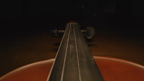 Slider shot down the neck of a violin, as the headstock disappears into Stock-Footage 120819976
