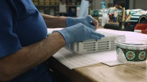 Slider shot of elderly worker's hands inspecting and cleaning a finished Stock Footage 115699931
