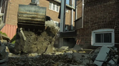 Slider shot of Excavator lifting large peice of rubble 库存影片 40648907