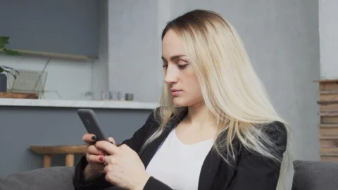 Slider shot of girl using smart phone for text messaging at home Stock Footage 103614816