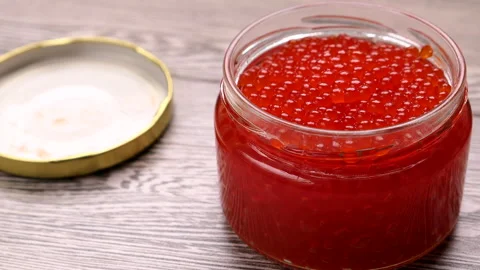 Slider Shot A Jar Of Red Caviar With Lid On A Gray Wooden Background. Close-up . Stock Footage 132413331