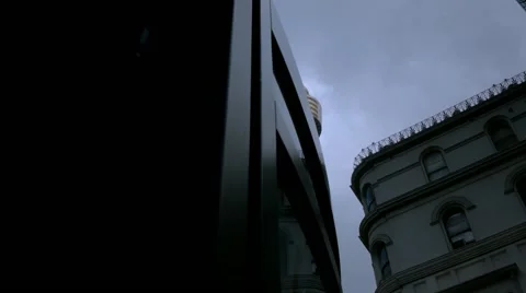 Slider shot moving from behind a bus shelter of sky scrapers. Stock Footage 68495949
