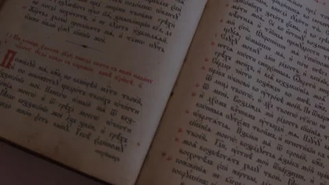 Slider shot over pages with candle wax stains of old antique religious book Stock Footage 254403799