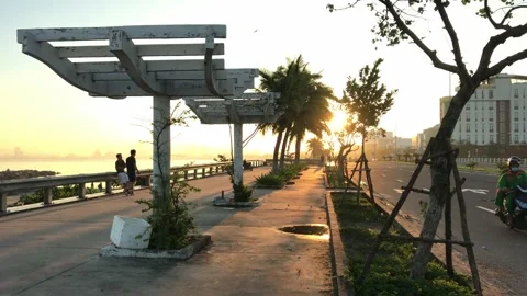 Slider shot of people doing exercise and sunset street scenery by the beach of Stock Footage 143990066