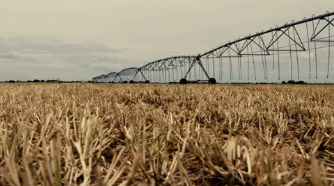 Slider shot slow motion fallow field and circle sprinkler Stockbeeldmateriaal 59325337