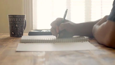 A slider shot of a student doing math homework on a table Stock Footage 94015482