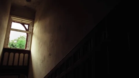 Slider shot of window in staircase of abandoned, old, hunted building Video stock 81778314