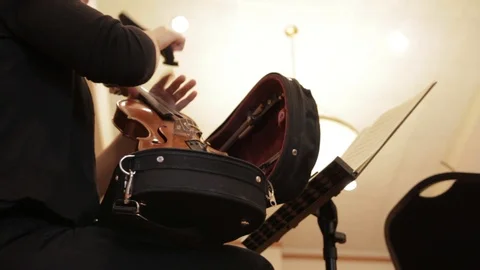 Slider shot of woman pulling violin out of case. Stock Footage