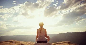 Slider shot of young woman meditating on the edge of a cliff Stock Footage 85776942