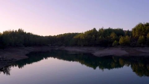 Sliding back smoothly over a little natural, ecological lake surrounded by pi Stock Footage 121810326