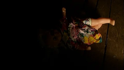Sliding beam of light illuminates the doll lying on the floor Stock Footage 120246939